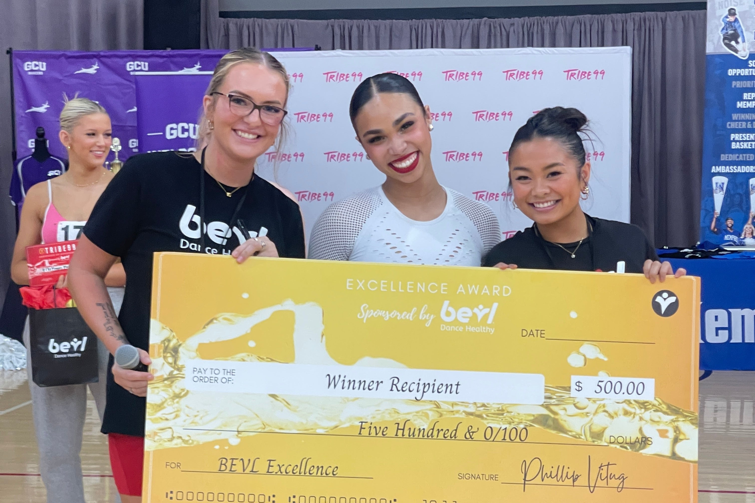 People holding a large award check with a branded backdrop